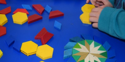a child works with colorful shape tiles