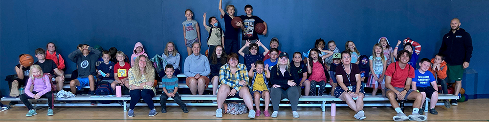 A group of students and staff on bleachers making silly faces