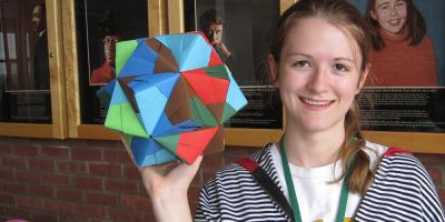 female student holding geometric shape